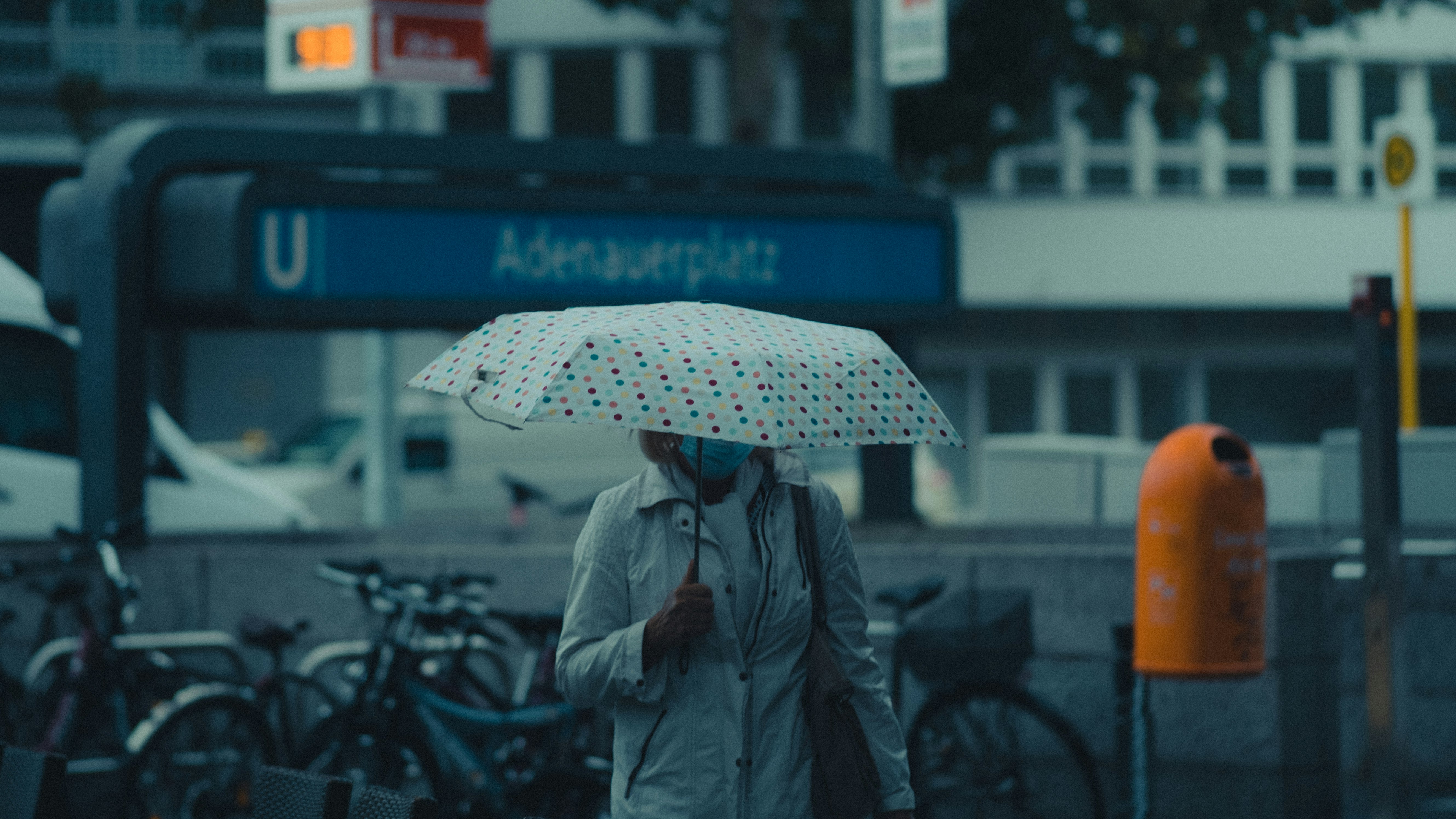 person in gray coat holding umbrella